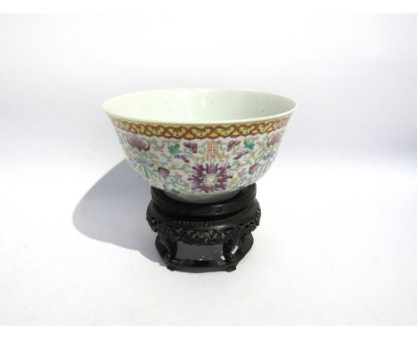 A Chinese porcelain bowl with five-clawed dragon emblem to interior, enamel repeating pattern to exterior with carved ebony s