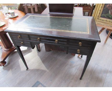In the manner of 'Maple &amp; Co.' an Edwardian writing desk the gilt tooled leather writing surface over five drawers and kn