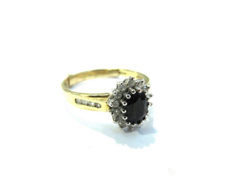 An 18ct gold sapphire and diamond cluster ring with diamond set shoulders, size Q/R 4.8g