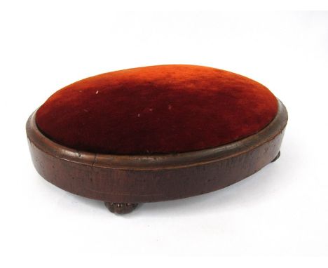 A pair of Victorian mahogany oval footstools with velvet upholstery over melon fluted ceramic feet 