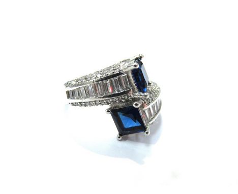 An Art Deco style wrap over design ring, multi set with blue and white stones, size S/T