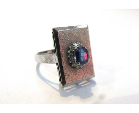 A dress ring, the square mount centre set with sapphire, framed by diamond chips, unmarked, size O/P 