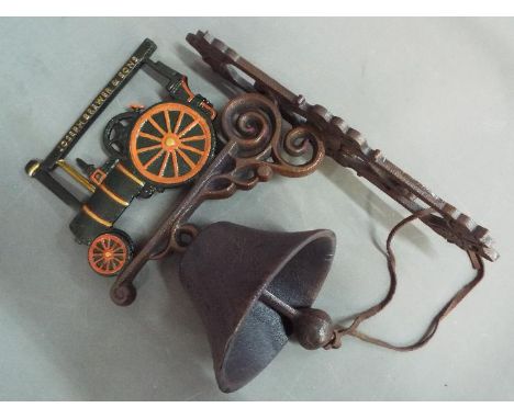 A cast iron, wall mountable bell surmounted with a depiction of a traction engine. [XTEBE]
