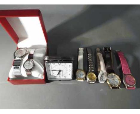 A collection of wristwatches and a travel alarm clock 