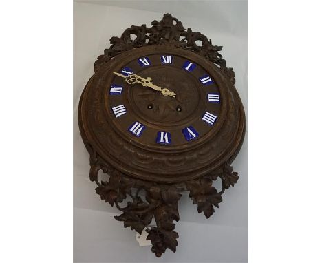 Late 19th century, profusely carved black forest wall clock with 8 day movement and enamel capitals. 