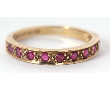 A 9ct ruby half hoop ring, the upper half set with small round rubies, with plain lower band hallmarked London 1980, size K-L