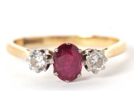 An 18ct and platinum ruby and diamond ring, the central oval ruby, calw mounted with a round brilliant cut diamond to either 