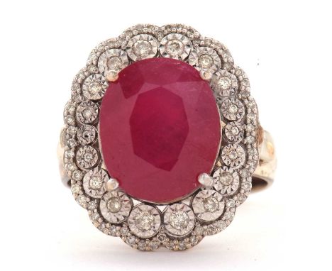 A 9ct ruby and diamond cluster ring, the central oval ruby, approx. 14 x 11.4 x 8.5mm, in a four claw mount and surrounded by