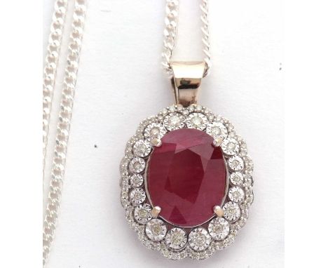 An 18ct ruby and diamond cluster pendant, the oval ruby, approx. 14 x 10.8 x7.6mm, in a four claw mount and surrounded by a r