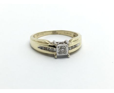 A 9ct gold solitaire diamond ring with further diamonds to the shoulders, approx.10ct, approx 2g and approx size K-L.