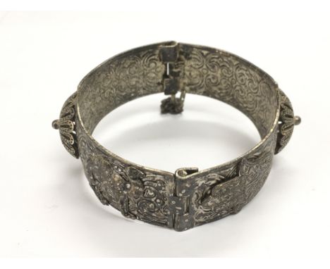A silver bangle decorated with Egyptian symbols and camels.