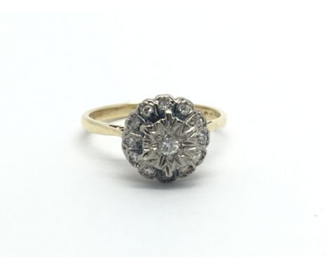 An 18 carat gold ring set with a cluster of diamonds ring size M.