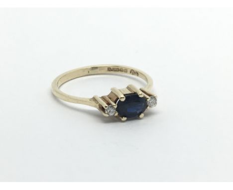 A 9ct gold eing set with a central sapphire and a diamond either side, approx 1.3g and approx size K-L.