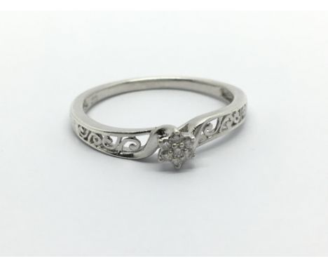 A silver ring set with seven small diamonds, approx 2g and approx size R-S.