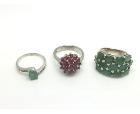 Two silver sings set with emeralds plus one other silver ring set with a cluster of rubies (3).