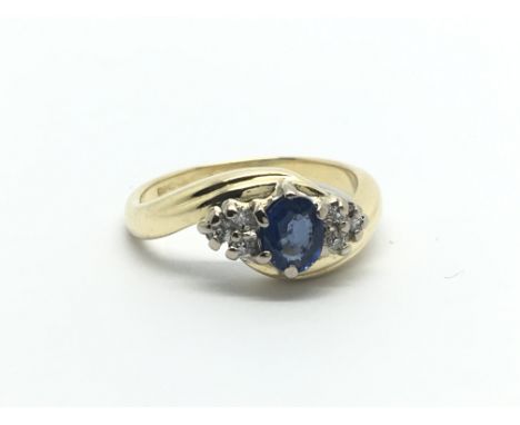 An 18carat gold ring set with a blue sapphire flanked by diamonds ring size G-H