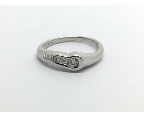 An 18ct white gold solitaire diamond ring with further baguette cut diamonds, approx.20ct, approx 3g and approx size K.