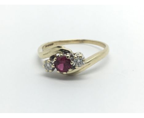 A 9ct gold ring set with a central red stone and two diamonds, aporox .20ct, approx 2.9g and approx size Q-R.