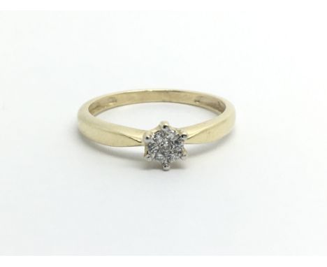 An unmarked gold ring set with seven diamonds in the form of a flowerhead, approx 1.6g and approx size N-O.