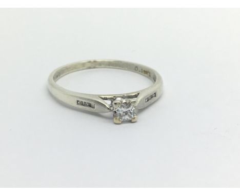 An unmarked white gold solitaire diamond ring set with a princess cut diamond and with further small diamonds to the shoulder