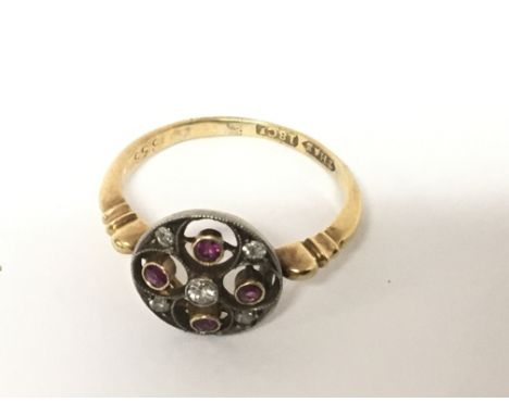 An Antique 18carat gold ring with an open scroll circular set with a pattern of ruby and old cut diamonds. ring size L weight