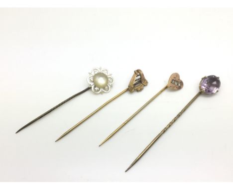 Four stick pins comprising a heart shaped example, one in the form of a lyre, an amethyst and a one mother of pearl.