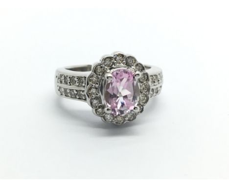 An unmarked white gold ring set with a central pink sapphire and surrounded by diamonds, approx 1/2ct, approx 5.6 g and appro