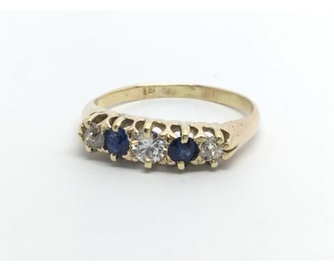 A vintage 18ct gold ring set with three diamonds and two sapphires, approx 2g and approx size I-J.