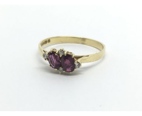 An 18ct gold ring set with two armadine garnets and four small diamonds, approx 2g and approx size O.