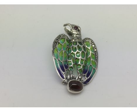 A brooch/pendant in the form of an eagle set in silver with cabochon garnet, marcasite, ruby and coloured enamel.