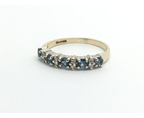 A gold ring set with alternating diamonds and topaz, approx 1.6g and approx size K-L.