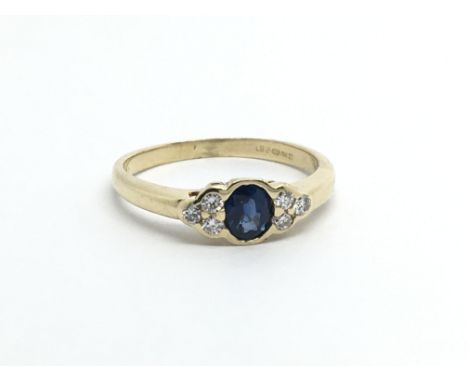 An 18ct gold ring set with a central sapphire and six small diamonds, approx 2.6g and approx size J- K.