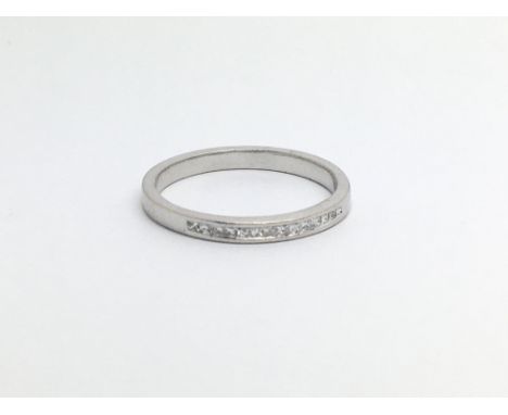 An unmarked white gold half eternity ring set with princess cut diamonds, approx 2.2g and approx size L.