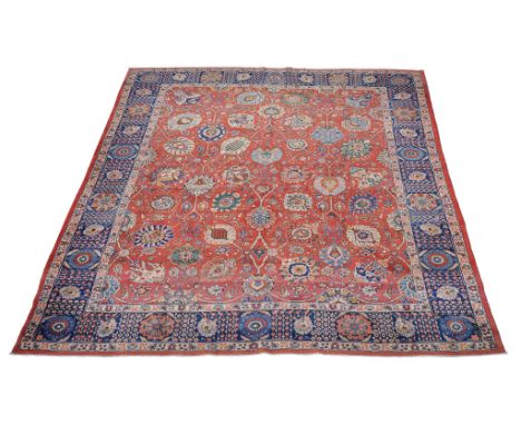  A Tabriz carpet,   of overall design, the madder field decorated with large flowerheads and meandering foliate branches, wit