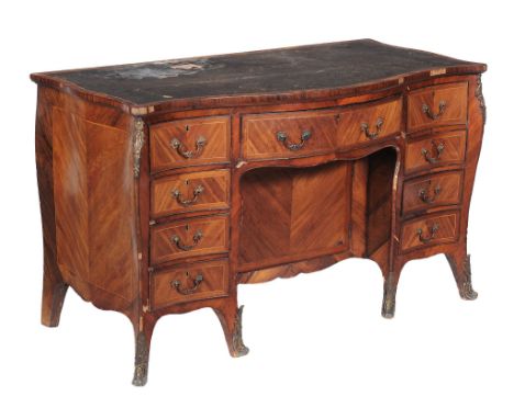  A George III mahogany, rosewood and goncalo alves serpentine desk, circa 1770, the tooled leather inset above an arrangement