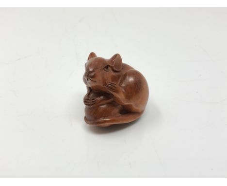 A carved Chinese hardwood netsuke - Rat on fruit