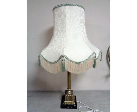 A brass Corinthian column table lamp with shade on a square marble base 