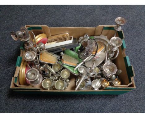 A box of early 20th century plated candelabra, egg cups on stands, plated cutlery, dressing table brushes etc 