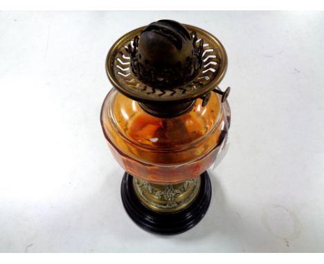 An antique brass Art Nouveau oil lamp on ceramic base with glass reservoir CONDITION REPORT: Lacks chimney