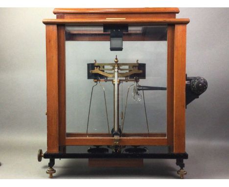 SET OF CHEMICAL BALANCE SCALES WITH A BOX OF EIGHT WEIGHTS the balance in glazed surround. 48cm high