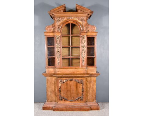 An Early 18th Century Pine Breakfront Bookcase of Architectural Form, the upper part with angled pediment and flanked by scro