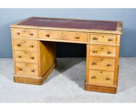 A Victorian Oak Pedestal Writing Desk, with moulded edge and red leather inset to top, fitted nine drawers under, on plinth b