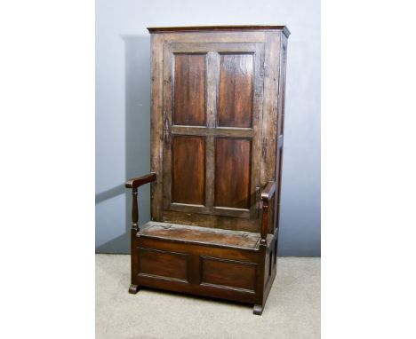 An Old  Oak "Bacon" Settle of 18th Century Design, with moulded edge to top, cupboard to back, enclosed by a single panelled 