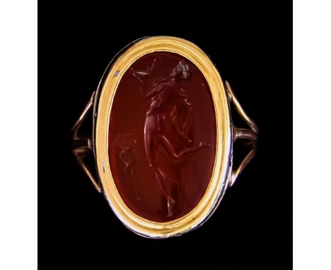 A Carved Carnelian Signet Ring, the polished stone carved with the figure of an angel, set in yellow metal (tests as 9ct), 20