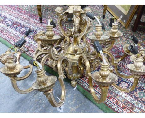 A HEAVY GILT BRASS EIGHTEEN LIGHT BAROQUE STYLE CHANDELIER, SCROLL ARMS WITH PUTTO MASK DECORATED SUPPORTS.   H.70 x W.86cms.
