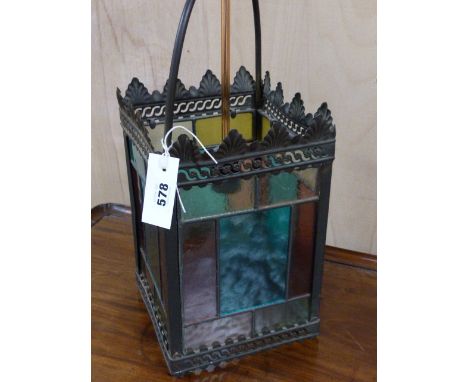 AN ANTIQUE BRASS FRAMED HALL LANTERN WITH LEADED STAINED GLASS PANELS.   H.64cms.