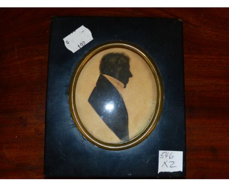 AN EDWARDIAN OVAL SILKWORK PANEL OF A YOUNG GIRL HOLDING A ROSE.   15.5 x 12cms. TOGETHER WITH A REGENCY OVAL SILHOUETTE PORT