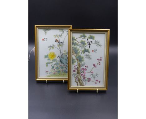 A PAIR OF CHINESE FAMILLE ROSE PLAQUES DECORATED WITH BIRDS AMIDST BLOSSOM, SIGNED WITH SEAL AND CHARACTER MARKS.   19 x 11.5