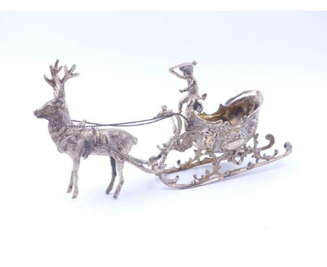 A CONTINENTAL SILVER MODEL OF A REINDEER PULLING A SLED SURMOUNTED BY A PUTTO. MEASUREMENTS 16cms X 8cms, WEIGHT 118grms.  