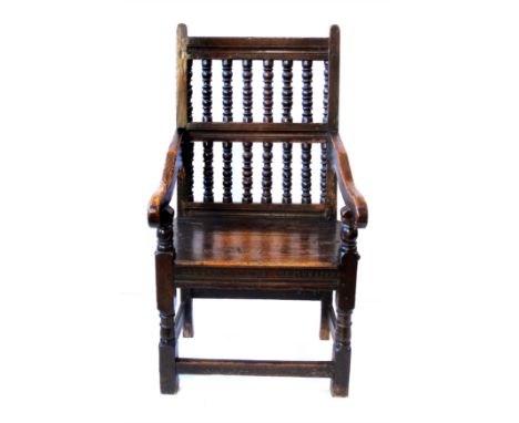 19th century oak framed tavern chair, back with two rows of bobbin turned spindles, open arms, solid seat, scratch carved fro